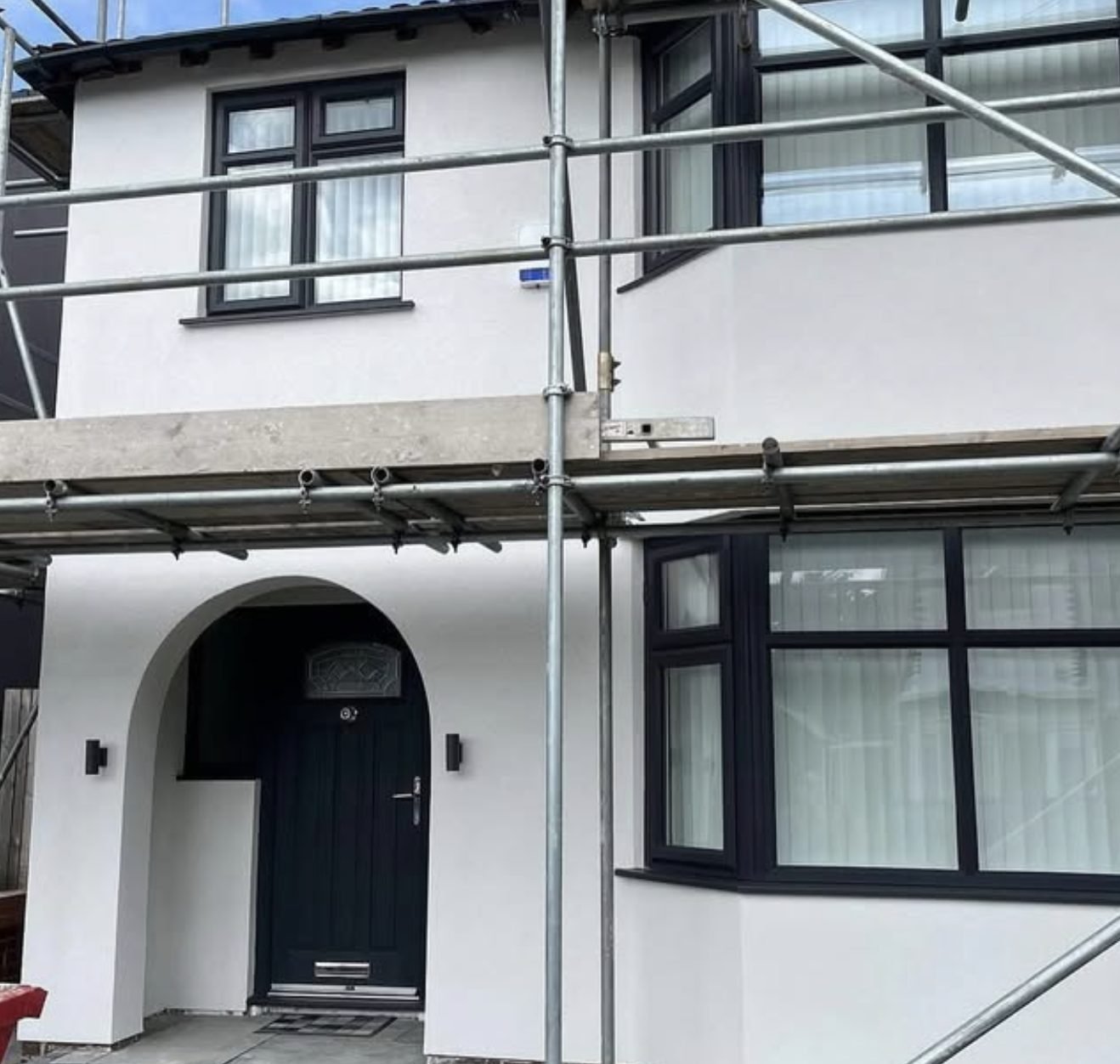 Semi-detached house part way through rendering with scaffolding still up